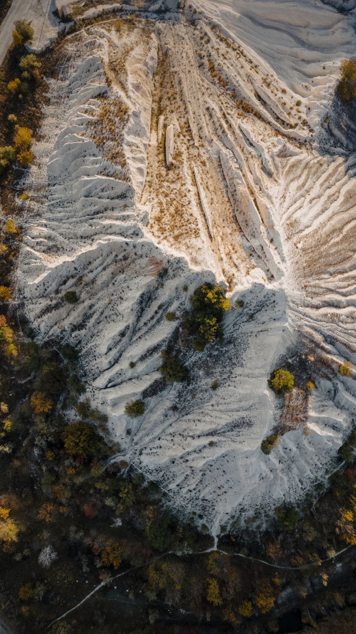 gallery-1 Stunning aerial shot of an eroded limestone quarry landscape with unique textures and formations.